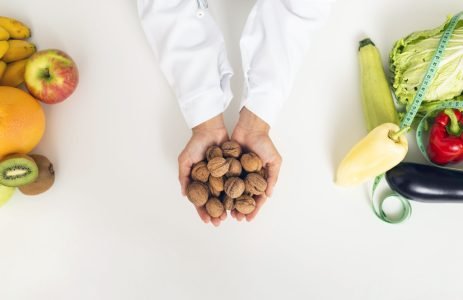 gros-plan-personne-legumes-tenue-noix